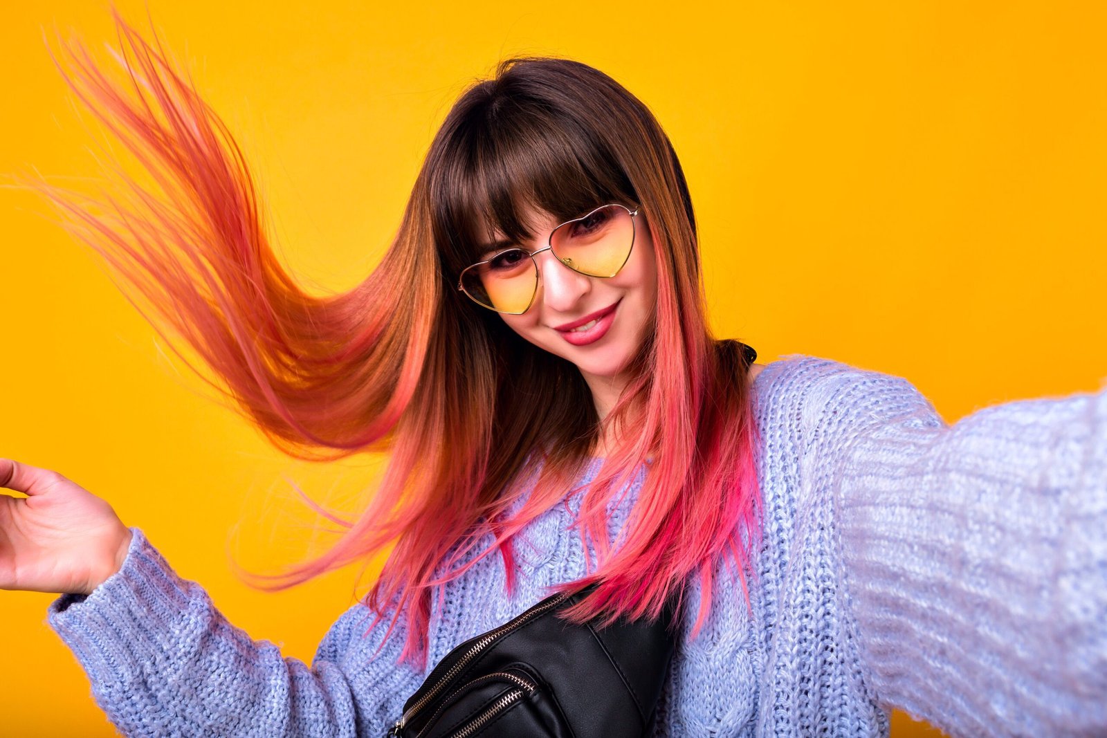 happy woman with unusual pink hairs making selfie yellow wall stylish cozy sweater hearted vintage sunglasses scaled